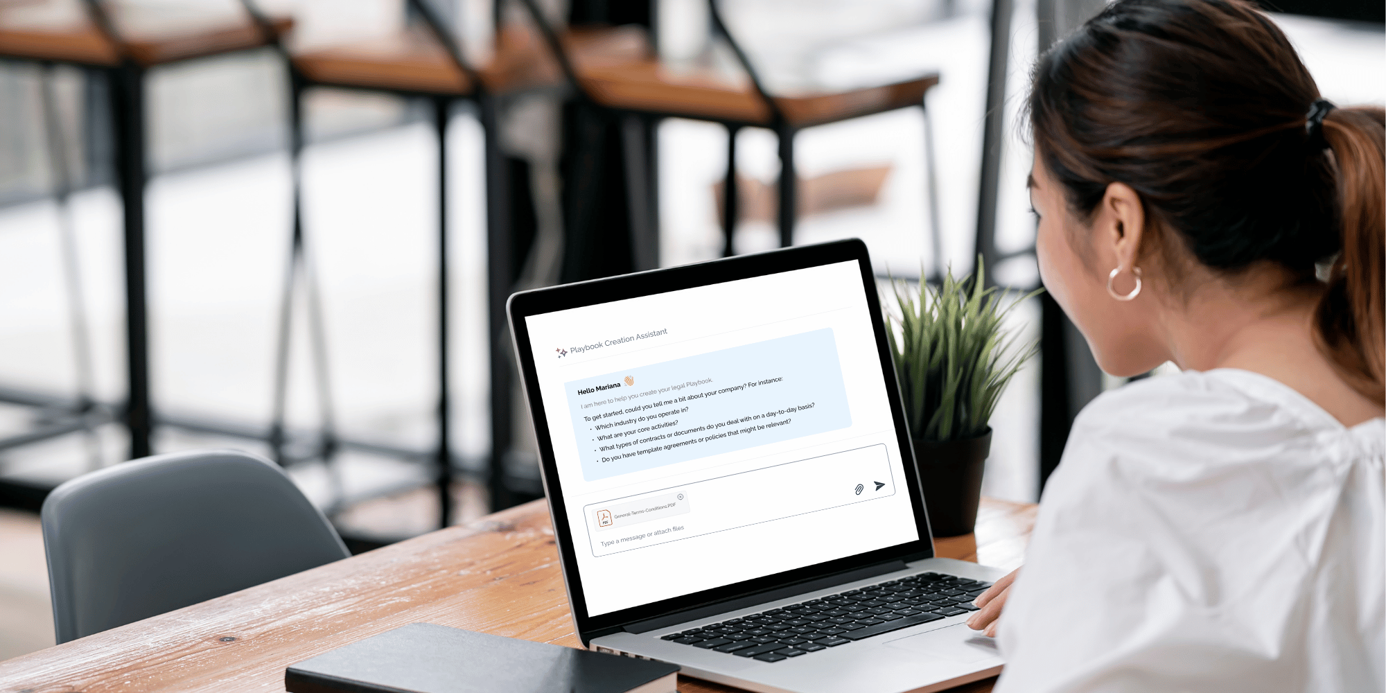 Woman is sitting in front of a laptop - shows how an AI is chatting about a contract playbook